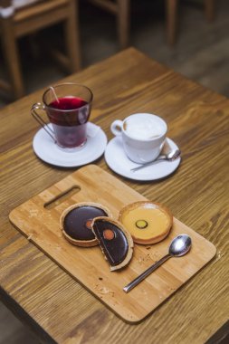 Kapuçino limon ve ahşap masa üzerinde koyu çikolata tart