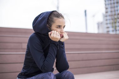 Endişeli, üzgün ve iç karartıcı genç kadın portresi dışında oturur