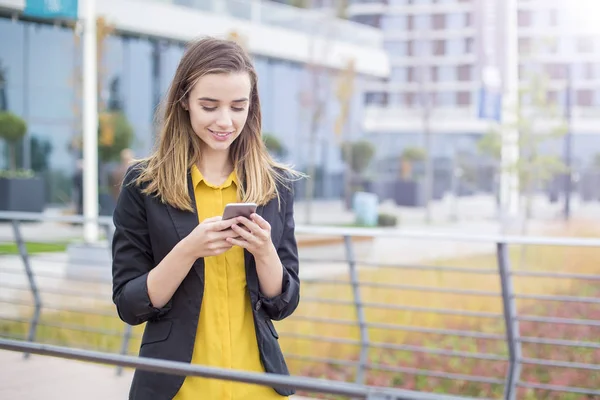 Jonge Zakenvrouw Messaging Mobiele Telefoon Buiten Met Kantoorgebouwen Achtergrond — Stockfoto