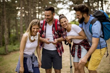 Grup dört arkadaşıyla birlikte bir orman yoluyla güneşli gün hiking