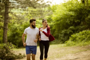Sağlıklı uyum ve sportif çift doğada yaz gününde çalışan