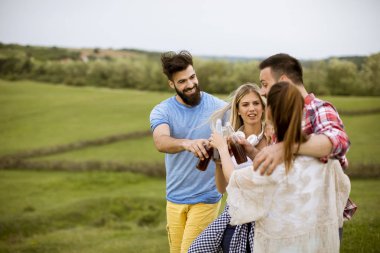 Mutlu grup arkadaşıyla birlikte eğleniyor ve doğa tarafından yaz gün gülümseyerek içki ile