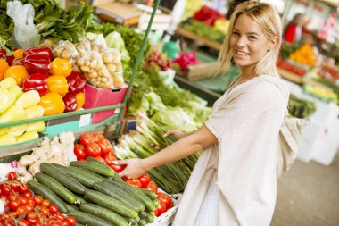 Genç ve güzel kadın Pazar sebze satın alma, görüntüleme