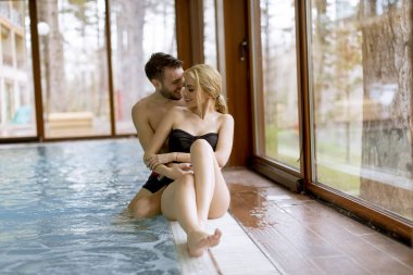 Yüzme Havuzu ile spa Center'da genç çift rahatlatıcı sevgi dolu