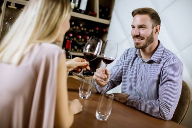 Genç mutlu çift romantik tarihte restoranda kadeh kırmızı şarap içmek