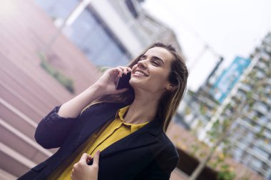 Genç neşeli iş kadını cep telefonu sokağın kullanır.