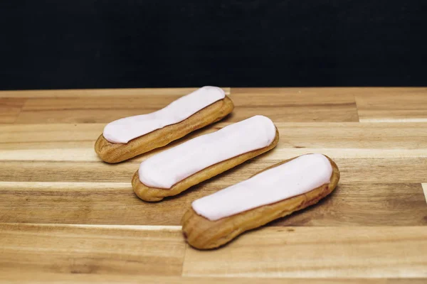 Ahşap Arka Plan Üzerinde Izole Eclair Gevrek Kremalı Pasta Beyaz — Stok fotoğraf