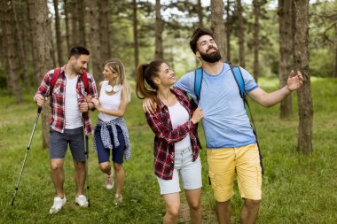 Grup dört arkadaşıyla birlikte bir orman yoluyla güneşli gün hiking