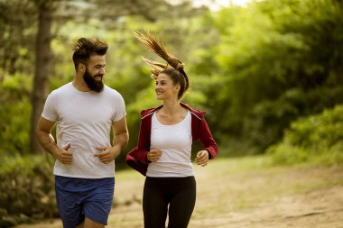 Sağlıklı uyum ve sportif çift doğada yaz gününde çalışan