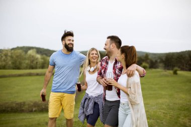 Mutlu grup arkadaşıyla birlikte eğleniyor ve doğa tarafından yaz gün gülümseyerek içki ile