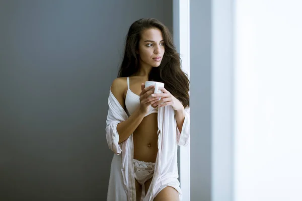 Mujer Joven Con Taza Café Neglige Pie Junto Ventana Habitación —  Fotos de Stock