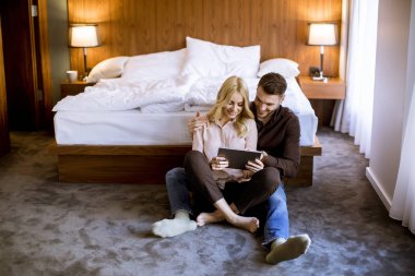 İnternet'te sörf kat dinlenme ve sahip eğlenceli üzerinde oturan aşık romantik genç mutlu çift