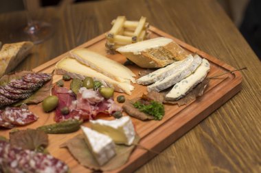 Peynir ve sosis meze olarak tahta masada servis