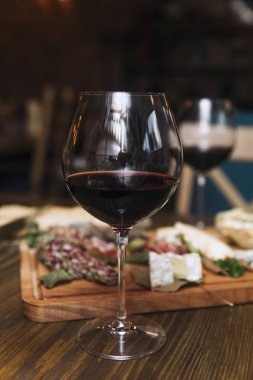 Peynir, sosis ve meze olarak kırmızı şarap ahşap masa servis