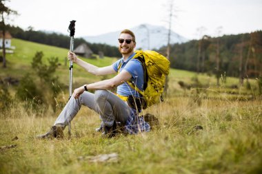 Yakışıklı genç Kızıl saçlı adam dinlenme Hill backpacking