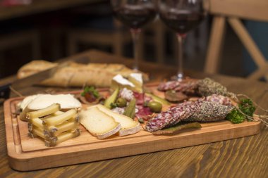 Peynir, sosis ve meze olarak kırmızı şarap ahşap masa servis