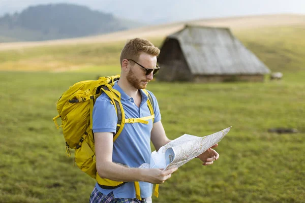 年轻的红头发男子在山区徒步 并在夏天拿着地图 — 图库照片