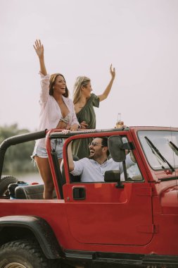 Mutlu genç arkadaşlar eğlenmeye Cabrio araba yaz tatili nehir kenarında grup