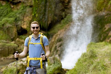 Dinlenmek için bir dağ şelale durdu yakışıklı genç uzun yürüyüşe çıkan kimse