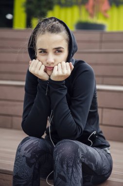 Yalnız açık oturan üzgün ve sinirli sportif genç kadın