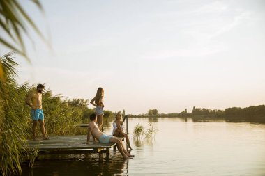 Genç insanlar bir yaz gününde gölde eğleniyor