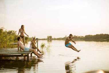 Genç insanlar bir yaz gününde gölde eğleniyor