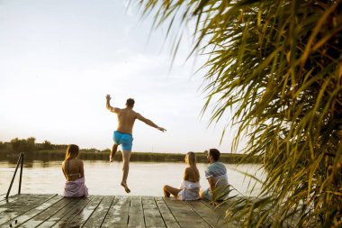 Genç insanlar bir yaz gününde gölde eğleniyor
