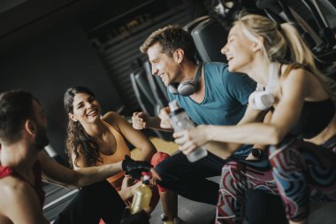 Bir egzersiz sonrası spor salonunda istirahat ederken birlikte konuşma ve gülüyor sporda grup PF genç insanlar