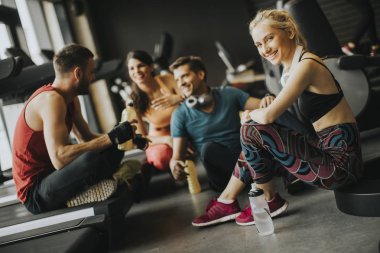 Bir egzersiz sonrası spor salonunda istirahat ederken birlikte konuşma ve gülüyor sporda grup PF genç insanlar