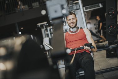 Güç egzersiz makinesi bir spor salonu kulüp ile bir geri egzersiz programı yapan atletik erkek