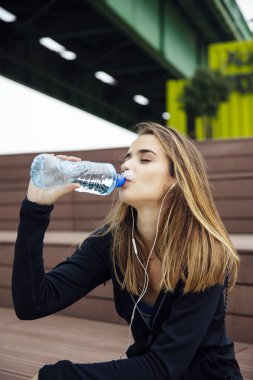 Genç Güzel kadınlar dinlenme ve içme suyu egzersizleri yaptıktan sonra açık