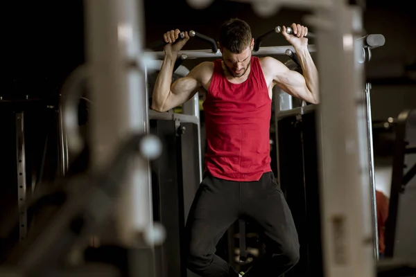 在健身房俱乐部里 用动力运动机做背部锻炼的运动员 — 图库照片