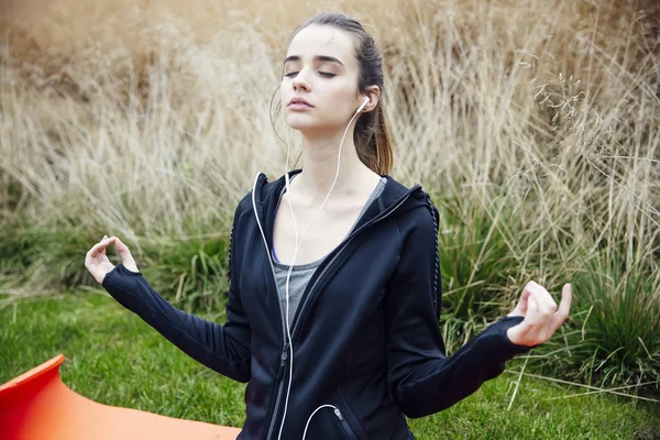 Young Woman Listening Music Doing Yoga Zen Pose Grass — Stock Photo, Image