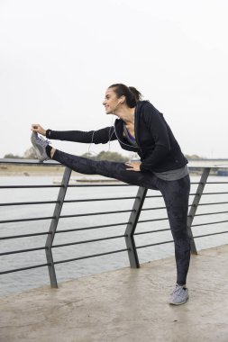 Güzel genç sporcu yapmak streching egzersizleri için bacaklar açık havada