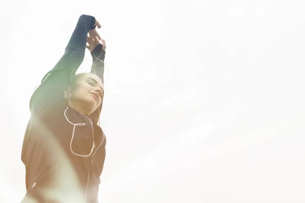 Молодая Спортсменка Растягивает Руки Слушая Музыку Открытом Воздухе — стоковое фото