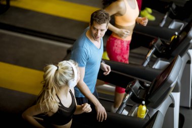 Modern bir spor salonu içinde koşu bandı üzerinde çalışan gençlerin grup, üstten görünüm