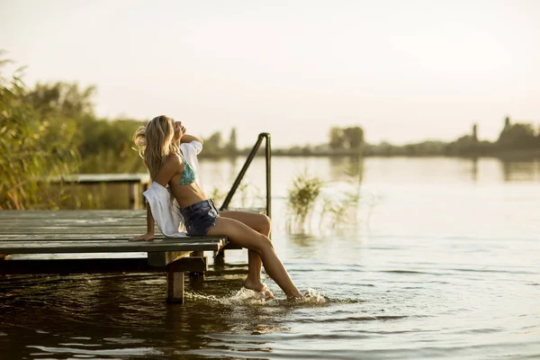 Ung Kvinna Sitter Piren Sjön Vid Solnedgången — Stockfoto