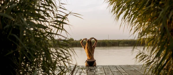 Visão Traseira Atraente Jovem Mulher Biquíni Sentado Cais Lago — Fotografia de Stock