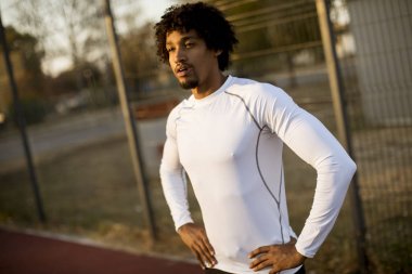 Basketbol sahasında ayakta kıvırcık saçlı çekici siyah adam yakın çekim