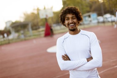 Basketbol sahasında ayakta kıvırcık saçlı çekici siyah adam yakın çekim