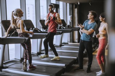 Spor salonunda konuşan bir grup spor kıyafeti antrenmandan sonra