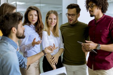 Modern ofiste ayakta duran ve görevden alan çok ırklı işadamlarından oluşan bir grup