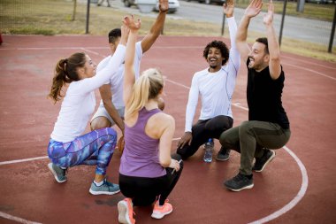 Gençlerin grup sahada basketbol oynarken çok ırklı