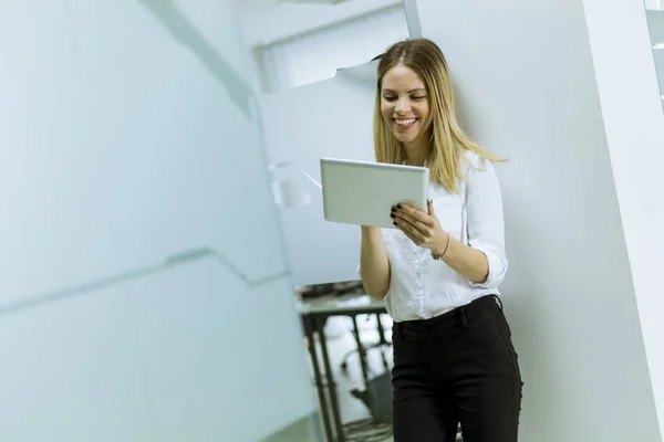 Jeune femme d'affaires debout avec tablette au bureau — Photo