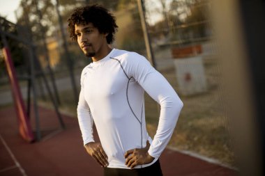 Basketbol sahasında ayakta kıvırcık saçlı çekici siyah adam yakın çekim