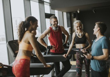 Spor salonunda konuşan bir grup spor kıyafeti antrenmandan sonra