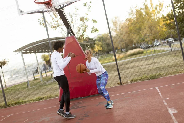 Grupo de personas multiétnicas jugando baloncesto en la cancha — Foto de Stock