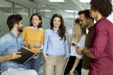 Modern ofiste duran ve beyin fırtınası olan çok ırklı bir grup genç