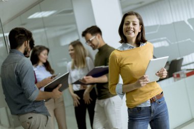 Takım lideri olarak meslektaşlarının önünde dijital tablet ile başlangıç ofisinde Pretty genç iş kadını