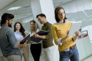 Takım lideri olarak meslektaşlarının önünde dijital tablet ile başlangıç ofisinde Pretty genç iş kadını